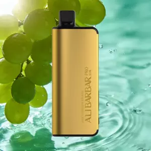 Gold rectangular vape pod with black top against a backdrop of green grapes and turquoise water ripples.